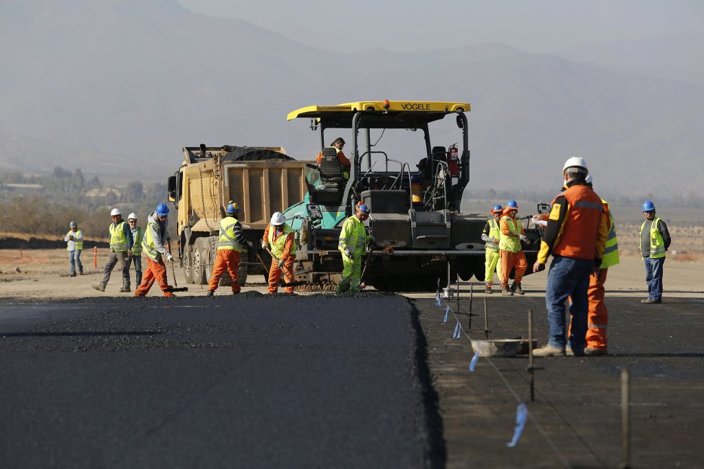 Trabajadores realizan faenas para mejorar una pista de un aeropuerto.